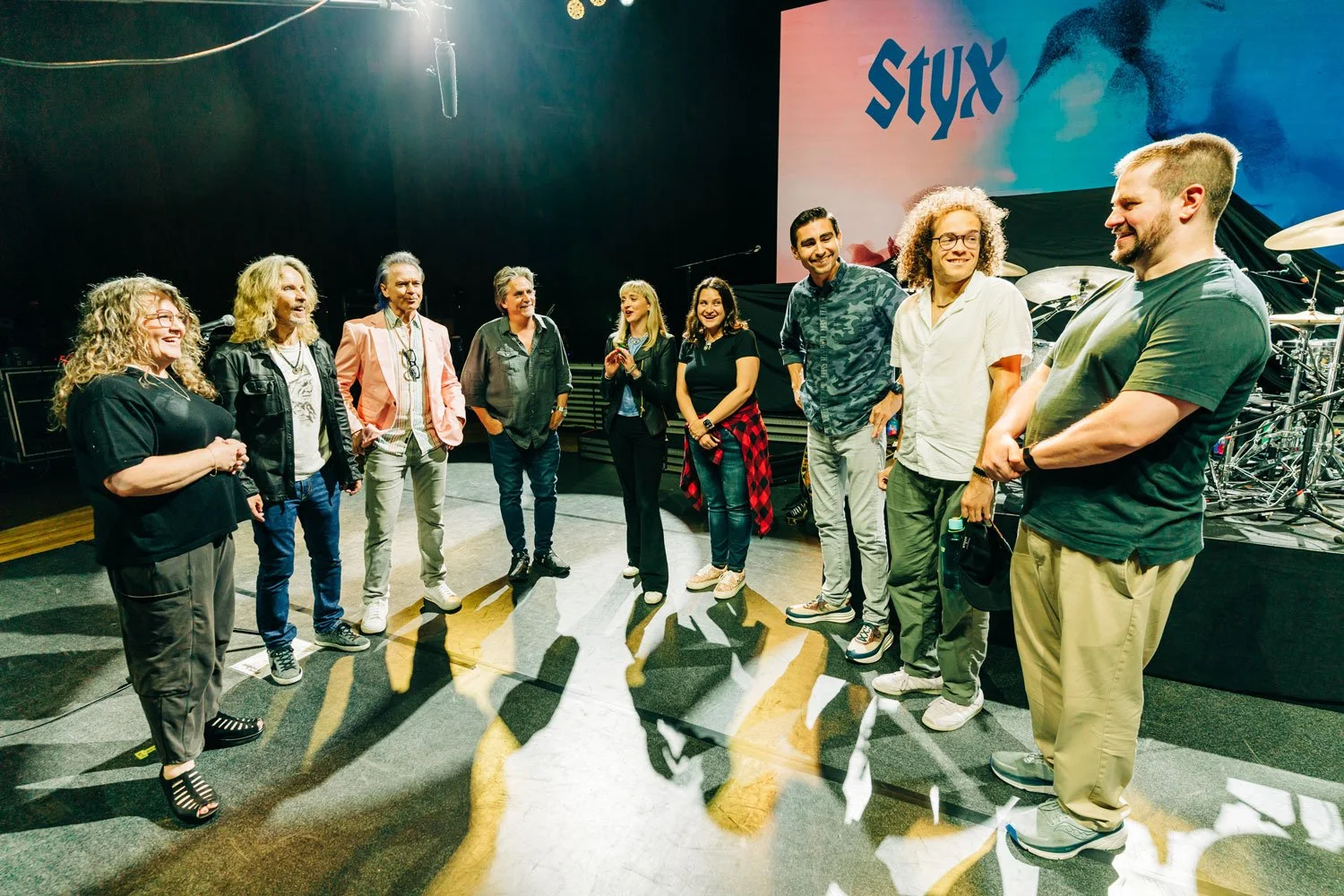 Musicians on stage under the Styx backdrop